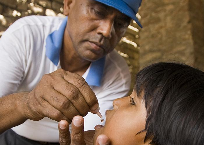 Health worker giving polio drops to a child
